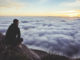 Innere Führung: ein Mann sitzt auf einem Felsen über einem Wolkenmeer
