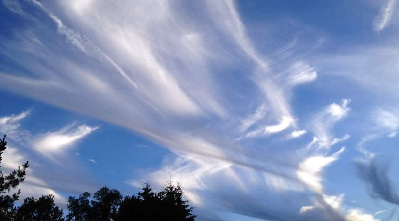 Wolkenmuster und menschliche Deutung Fadenförmige Wolken am blauen Himmel – Symbolbild zur Synchronizität