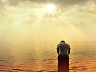 Mann gebeugt im Meer bei Sonnenlicht