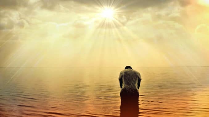 Mann gebeugt im Meer bei Sonnenlicht