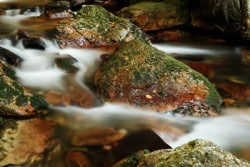 Wasser, das nebelig über Steine fließt