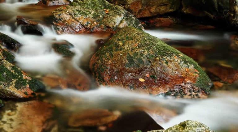 Wasser, das nebelig über Steine fließt