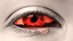 Seelenschmerz: Auge mit einer Träne und roter Landschaft in der Iris