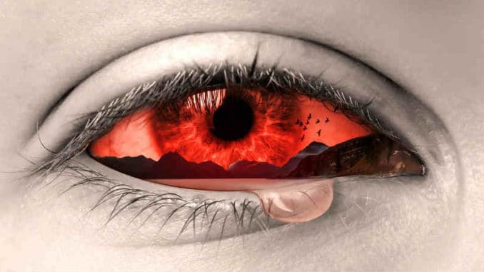 Seelenschmerz: Auge mit einer Träne und roter Landschaft in der Iris