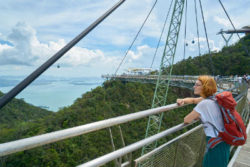 frau-mit-ucksack-auf-bruecke-und-selbsterfahrungs-tripp-girl