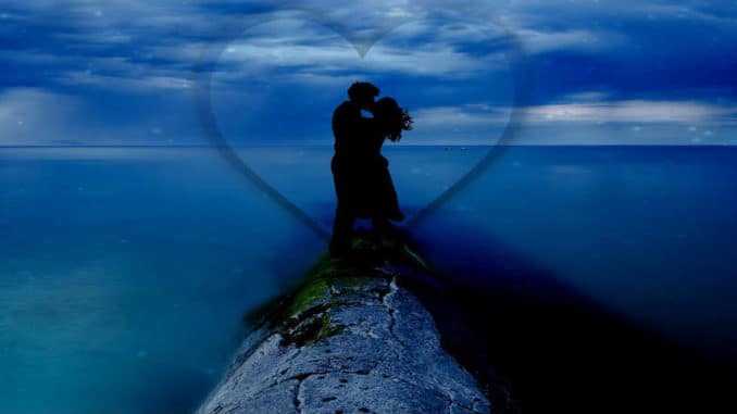 Karmische Liebe: Fotomontage eines sich umarmenden Paares am Meer mit einem Herz
