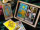 Tarotkarten mit Welt, Stern, Turm und Narr auf grünem Stoff neben Rosen