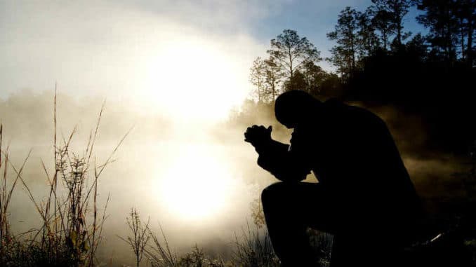 Wer bin ich? Symbolbild einer sitzenden Silhouette im Morgennebel