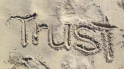 Vertrauen stärken durch Rituale: das englische Wort Trust als Schrift im Sand