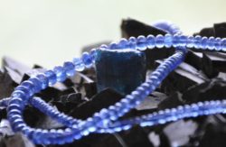 Energien der Kristalle: blaue Saphirperlen auf dunklen Steinen
