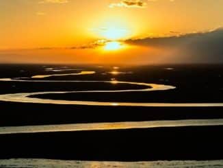 Sonnenaufgang über einem Fluss in der Prärie