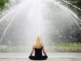 Frau meditiert vor einem Springbrunnen – Symbolbild für bewusste achtsame Ernährung