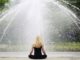 Frau meditiert vor einem Springbrunnen – Symbolbild für bewusste achtsame Ernährung