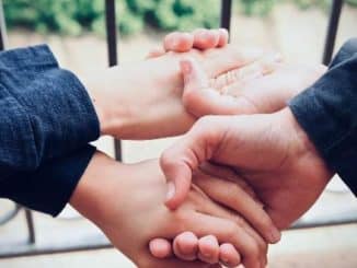 Verlässlichkeit als Bildmotiv: Hände halten einander an den Handgelenken