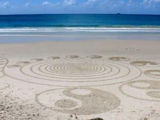 Yin und Yang: in den Sand gezeichnete Symbole am Meer