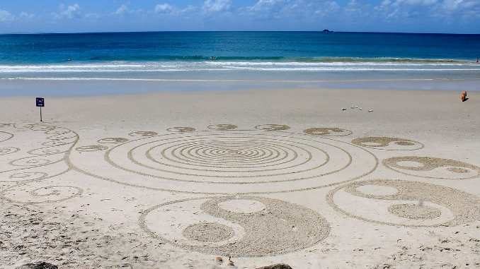 Yin und Yang: in den Sand gezeichnete Symbole am Meer