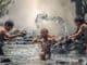 Naturreligionen: Symbolfoto mit Kindern, die im Wasser spielen