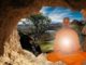 Meditierender Mönch im orangefarbenen Gewand vor einer Seenlandschaft
