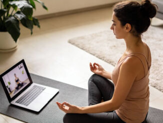Frau praktiziert Yoga auf dem Boden