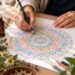 eine Frau malt ein Mandala