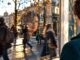 Spiegelbild einer Frau, überlagert von Straße und Passanten